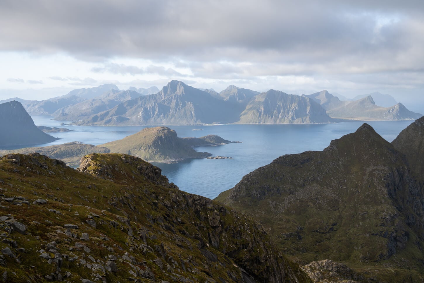 View of the southern mountains of the Lofoten under a partly cloud sky, but well lit by the sun.