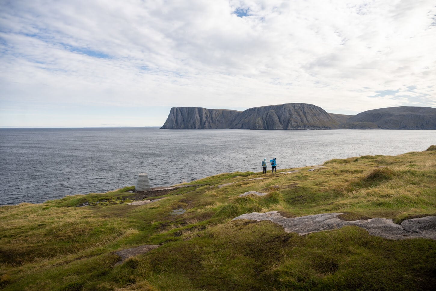 Knivskjellodden with hikers looking at the North Cape Plateau.