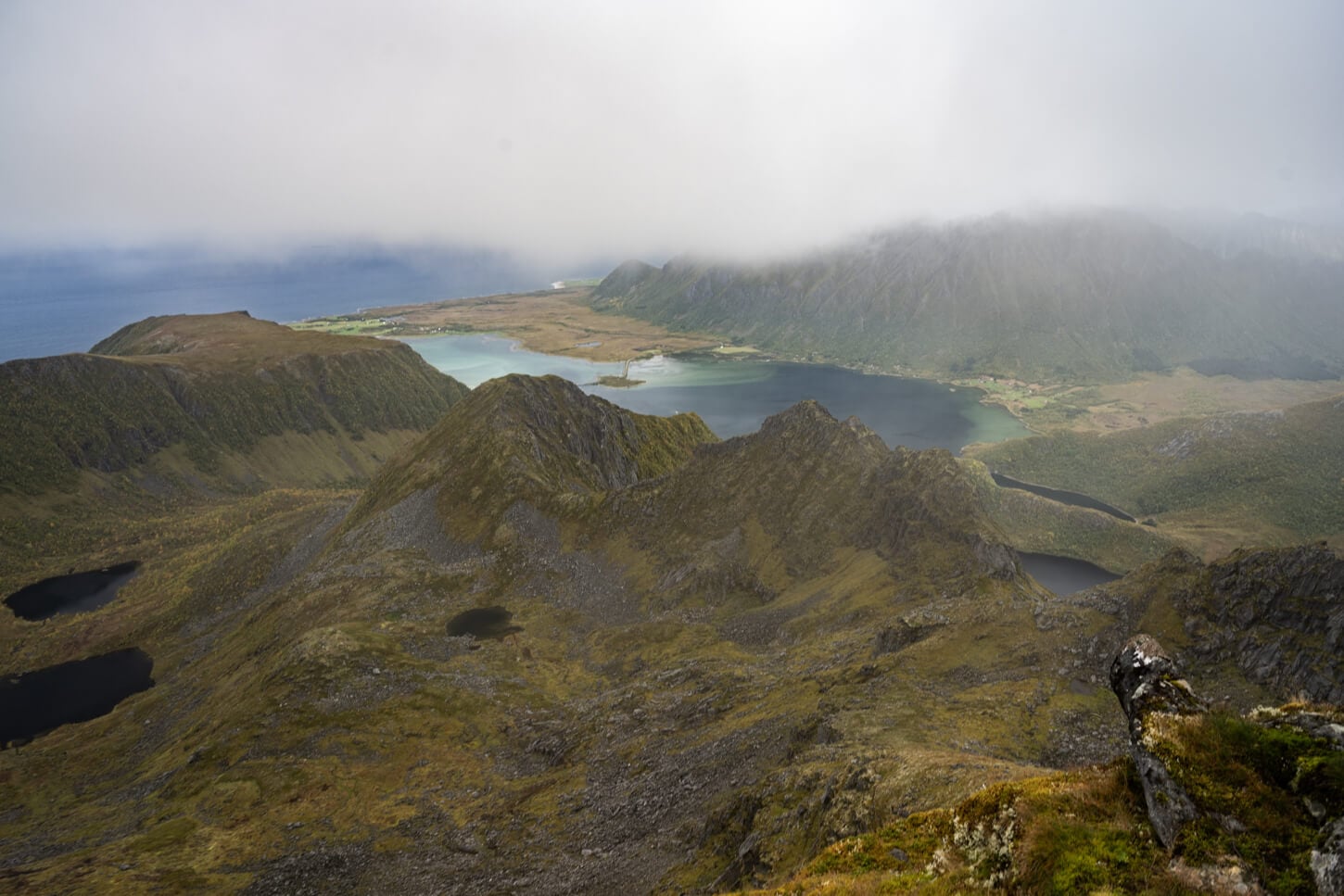 View of the landscape from Matmora's summit, with the fjord in the distance merging into the ocean.
