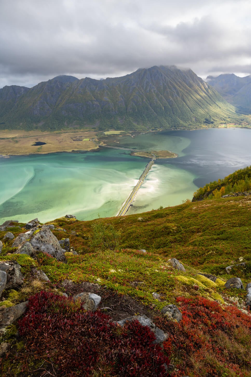 View of the landscape from Delpsheia's summit in the Lofoten island, from the hike to Matmora, on a cloudy day with some sun breaking through the clouds.
