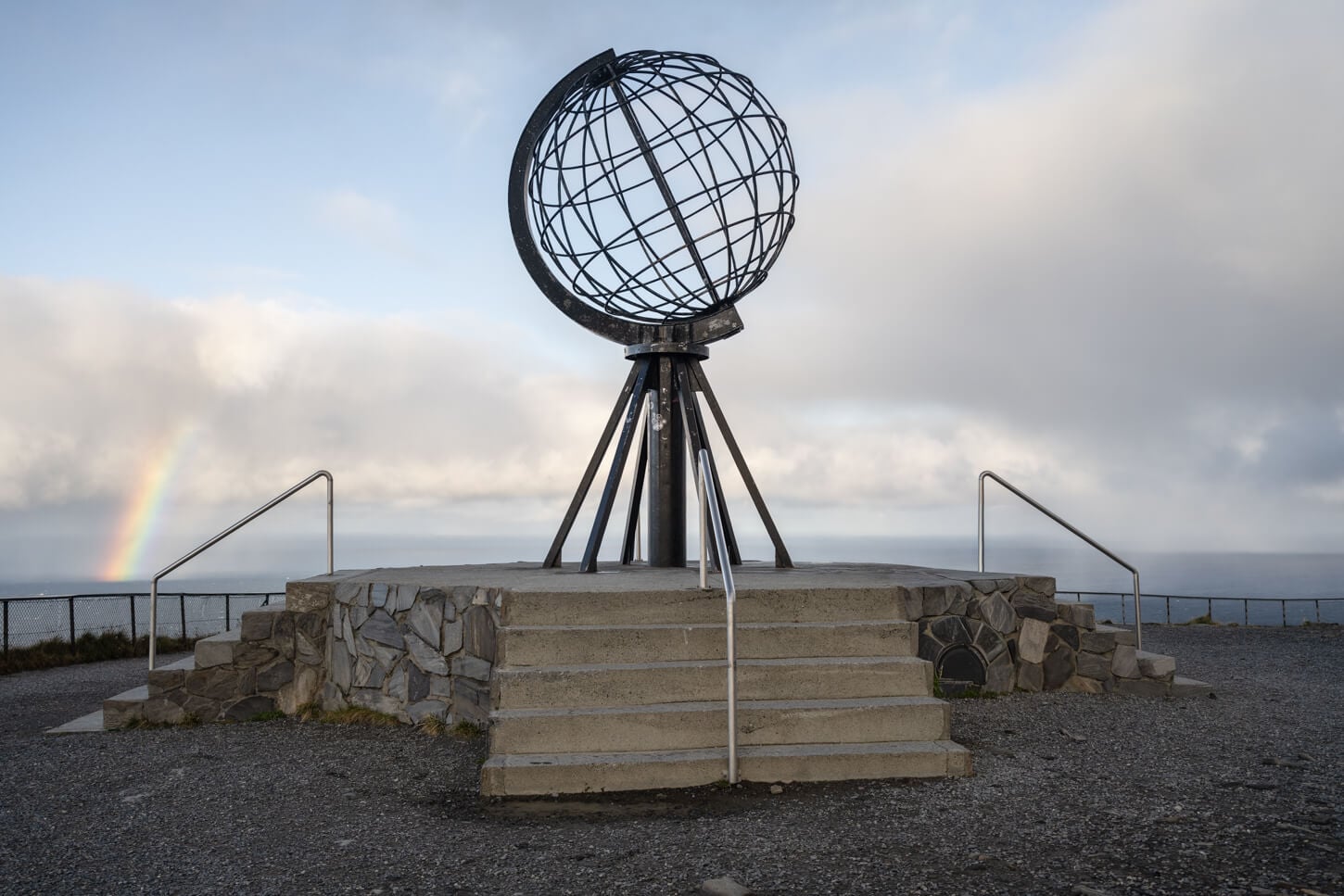 North Cape Monument globe with a rainbow in the background.