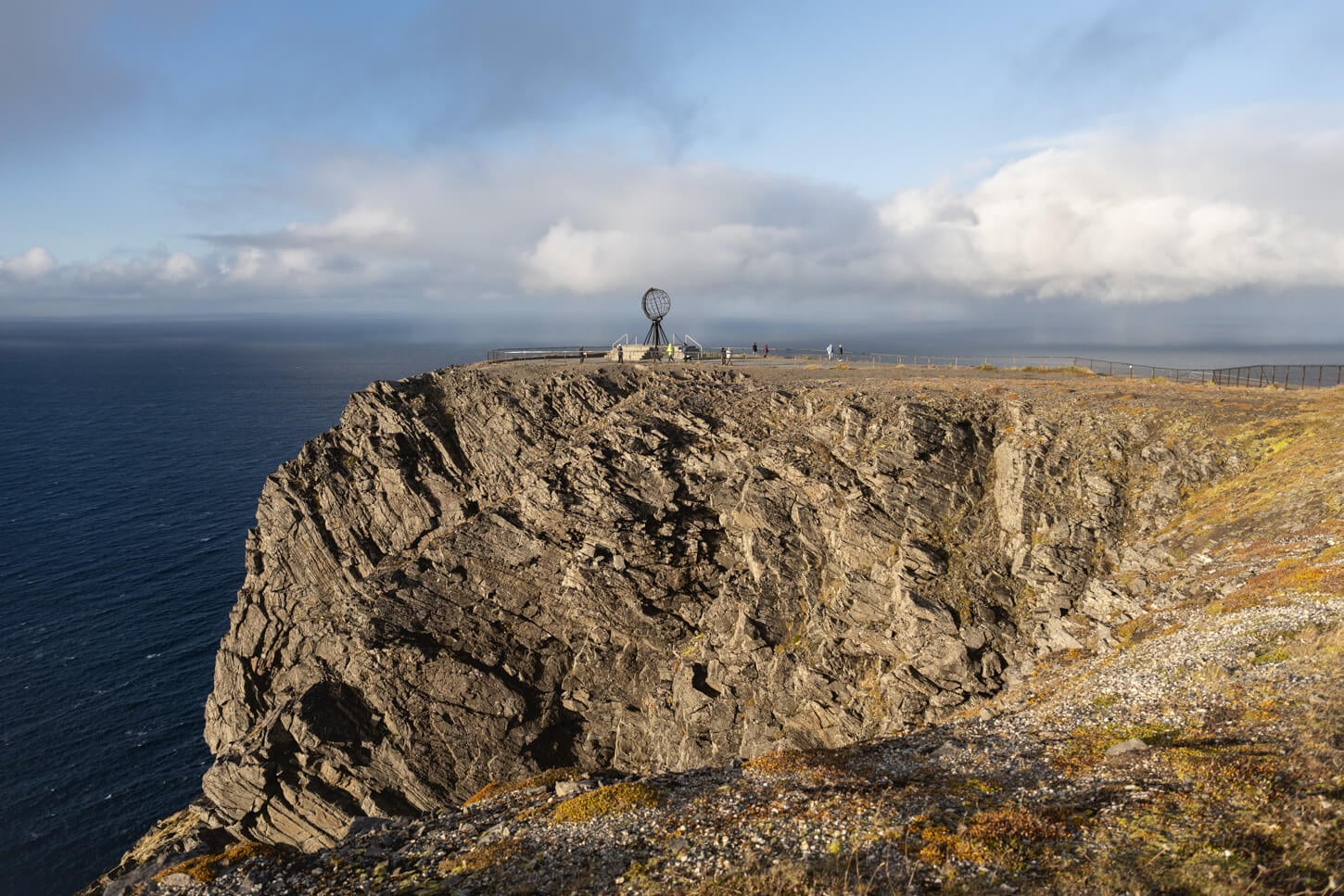 View of the Nordkapp globe monumet from a distance, with the open seas of the arctic ocean in the background.