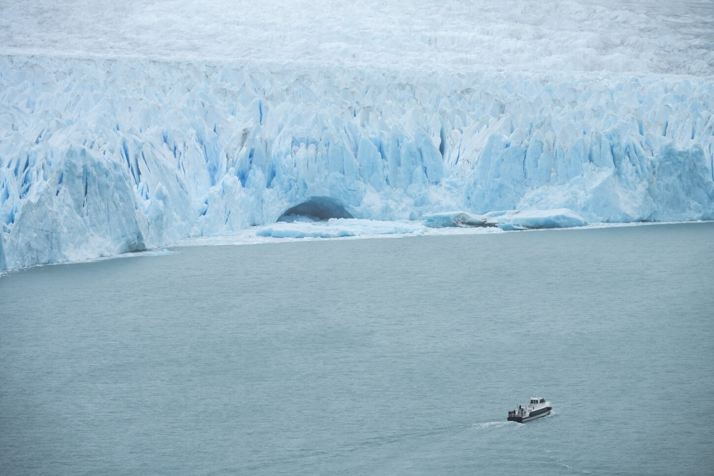 Perito moreno's Glacier Fron in patagonia with a small boat in front of it to show the scale
