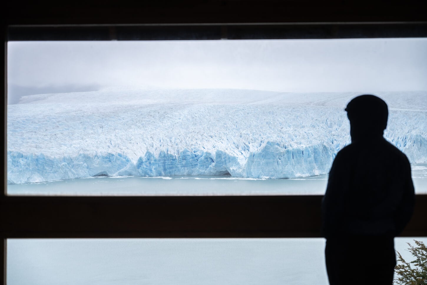 Perito Moreno Glacier viewed from Primer Balcón, with the figure of a parson looking at the glacier in the background.
