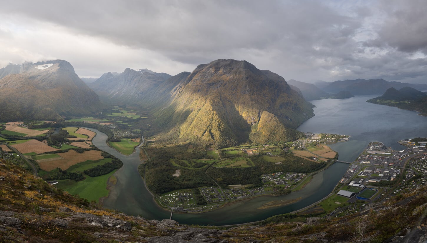 Panoramic image from Nesaksla with the Rauma River and valley under the morning light and a partially overcast sky.