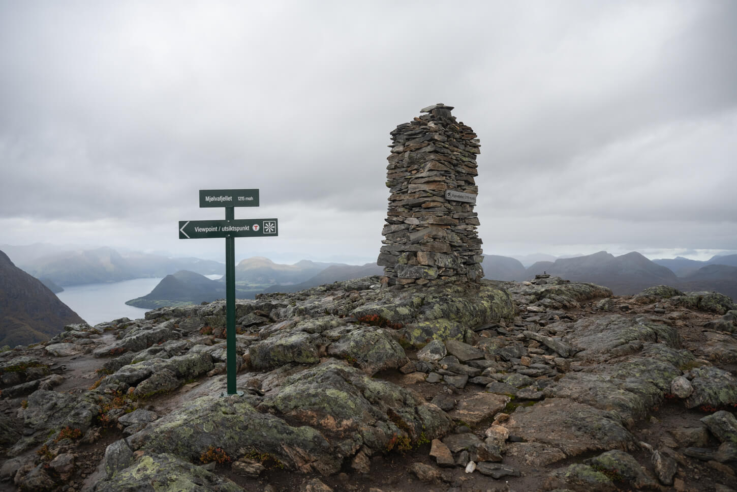 Mjølvafjellet Summit woith a cair and a sign pointing to the Viewpoint