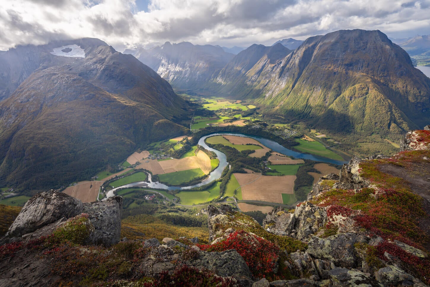 Dreamy view of the Rauma valley and river from the Romsdalseggen Ridge hike, with warm morning light shining on the valley