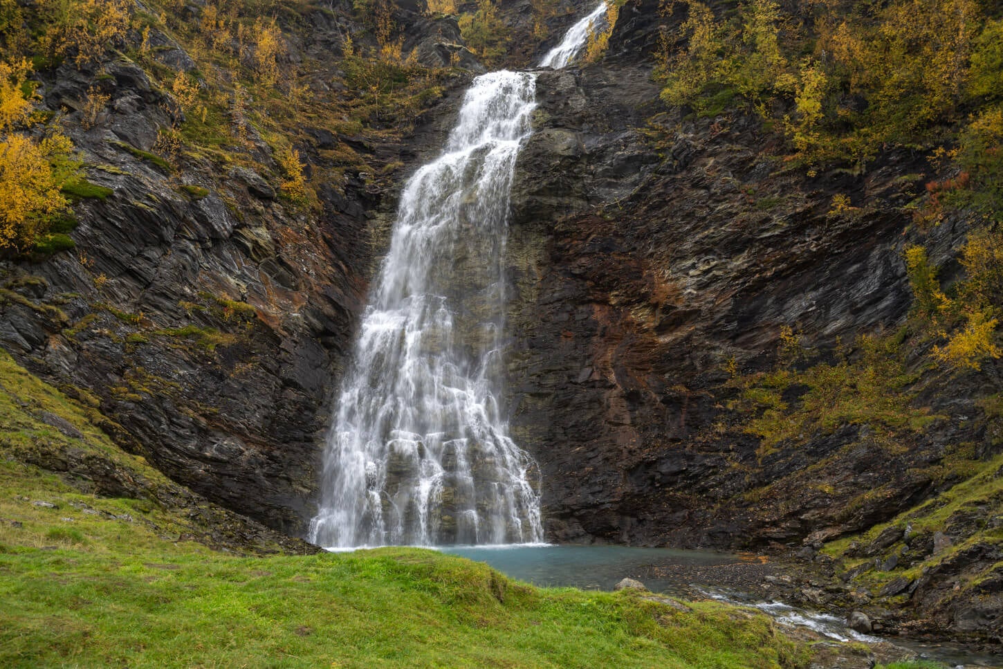 Rottenvikfossen falling in a pool of blue glacial water