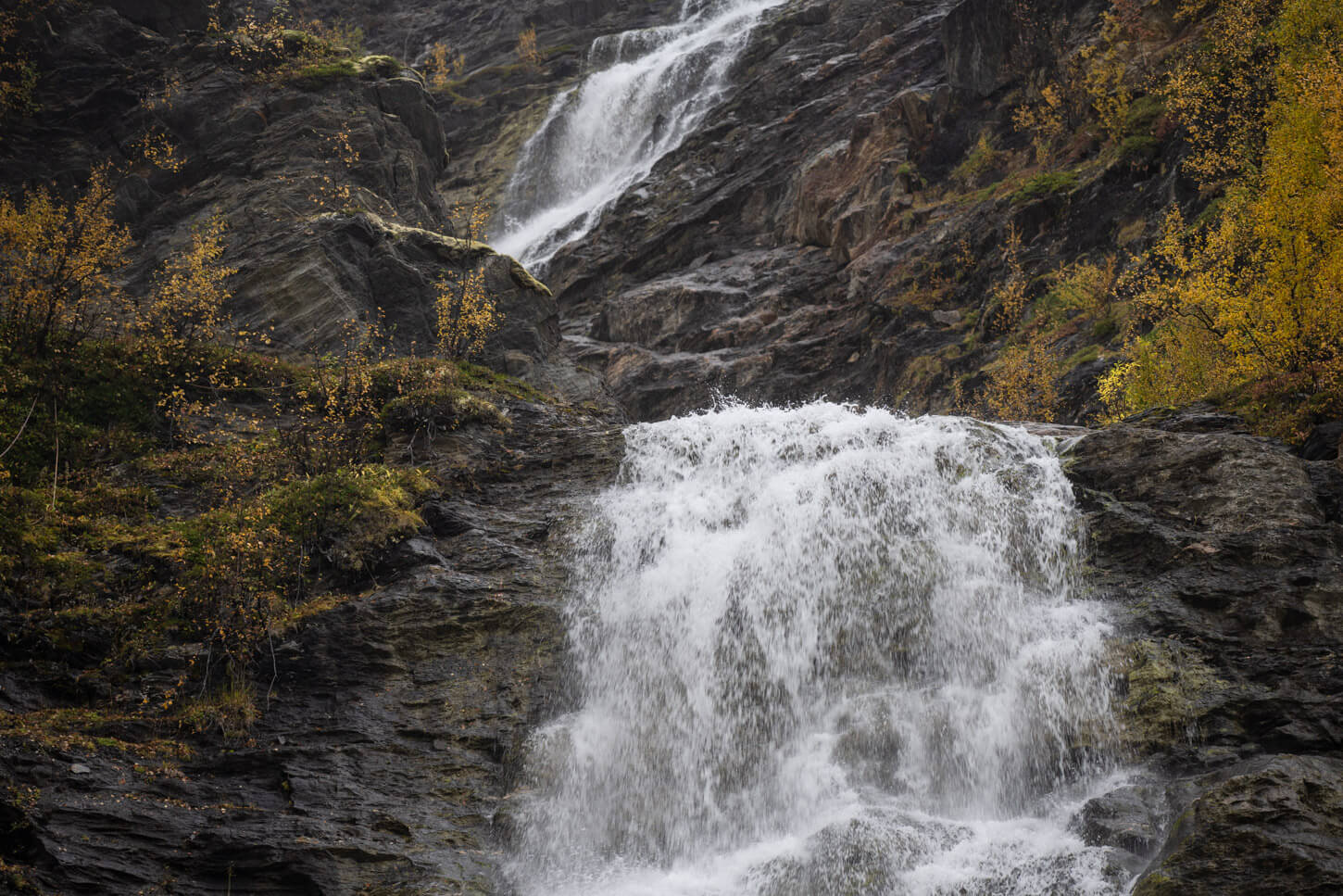 Details if the two steps of the waterfall, lower part of the upper and upper part of the lower step, with water cascading down the cliffs.